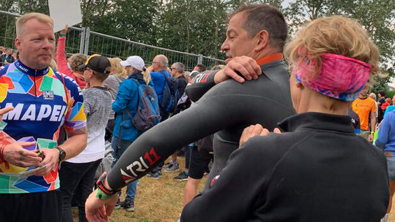 Vorbereitungen für den Schwimmstart: Thorsten Meusel (links) schaut zu, wie Oliver Schweizers Lebensgefährtin Irena ihm in den Neoprenanzug hilft. (Foto: nb)
