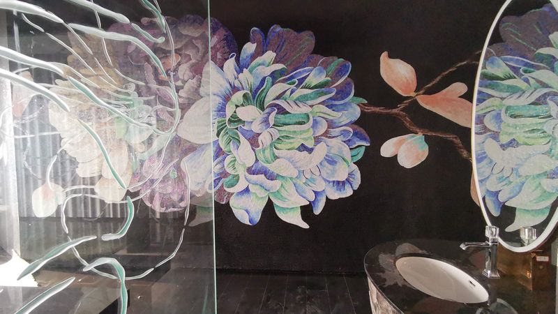 Ausladende florale Dekore finden sich in den Wellnessbereichen. Die Gestaltung zeigt leuchtende Farben vor einem dunklen Hintergrund.