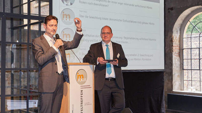 Martin Brühl (Union Investment) und Moderator Steffen Uttich (Beos) diskutieren mit dem Publikum vor der Tweetwall (Foto: Axel Schulten)