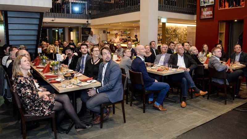 Eine Gruppe von Menschen sitzt in einem Restaurant und nimmt an einem geschäftlichen Treffen teil.