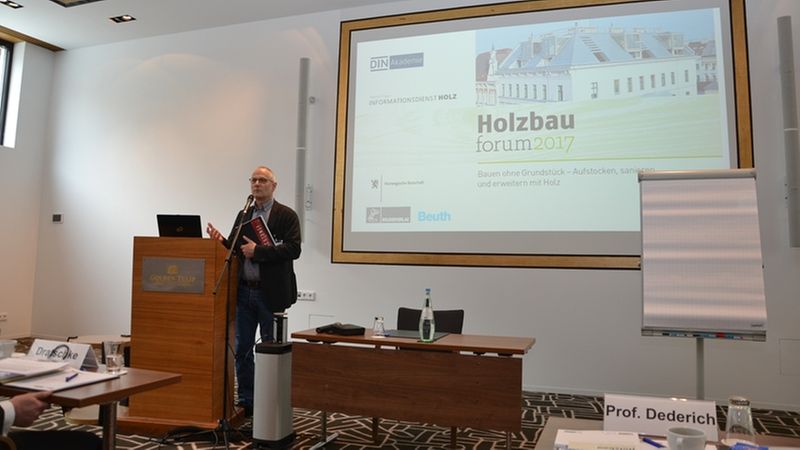 Ein Redner hält eine Präsentation auf dem Holzbau Forum 2017 in einem Konferenzraum.