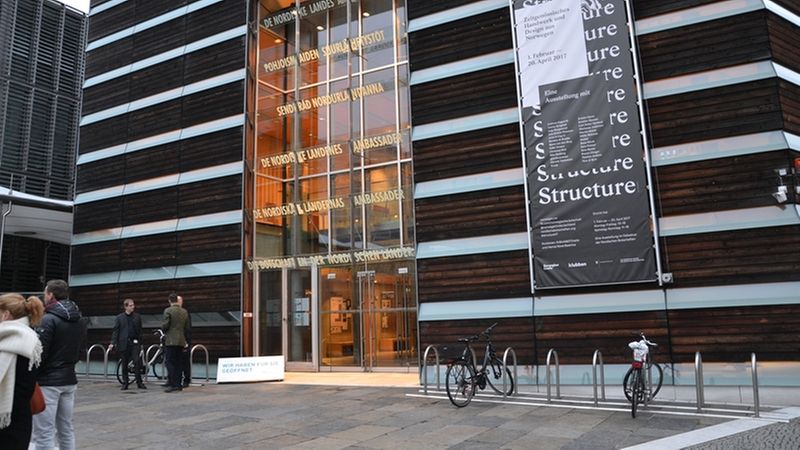 Ein modernes Gebäude mit einer Glasfassade und einem großen Banner an der Seite.