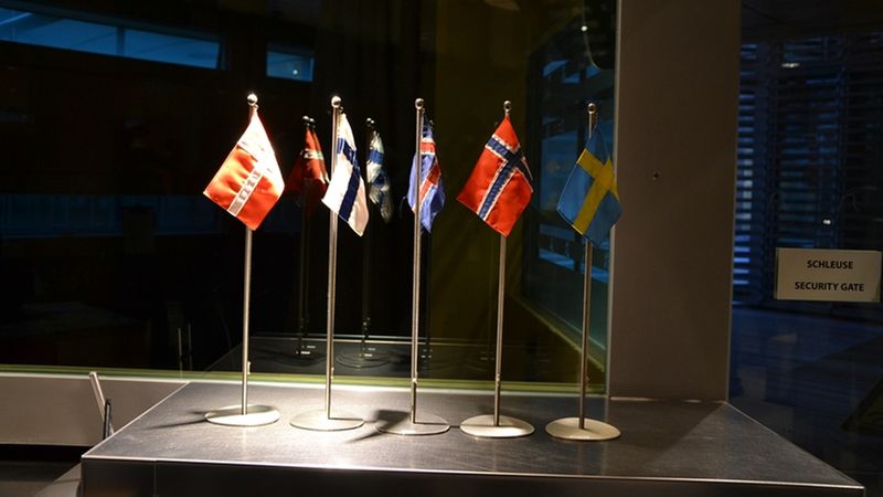 Ein Display mit mehreren nordischen Flaggen in einem beleuchteten Raum.
