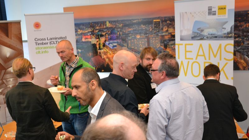 Eine Gruppe von Menschen bei einem Netzwerktreffen, die sich unterhalten und Snacks genießen.
