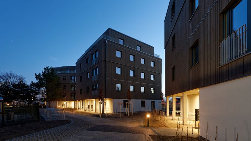 Beleuchteter Eingangsbereich: Rücksprünge in der Fassade markieren den Zugang zu den Gebäuden. Foto: Brünninghoff