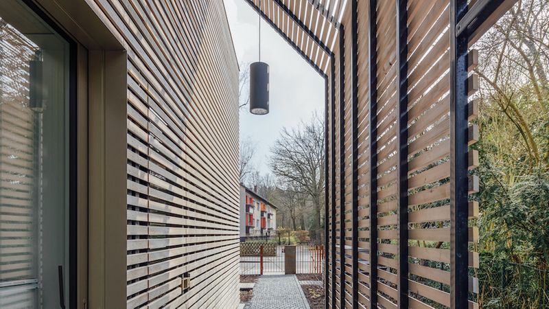 Hauseingang Pergola geschützt vor Sonne Wind Wetter. rundzwei Architekten Berlin. Foto: Gui Rebelo