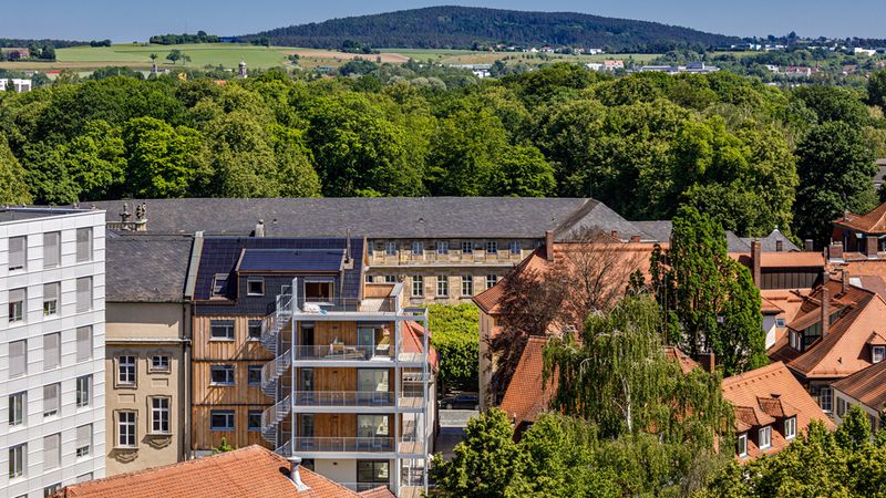 Das historische Stadtzentrum Bayreuths ist um ein inoffizielles Wahrzeichen reicher. Gegenüber des Neuen Schlosses und unmittelbar hinter dem Sitz der Regierung von Oberfranken errichtet die VIDA HolzProjekt GmbH in Zusammenarbeit mit holzius einen Wohngebäudekomplex der Gebäudeklasse 5 – in innovativer und zeitgemäßer Holzbauweise. Foto: Vida HolzProjekt GmbH