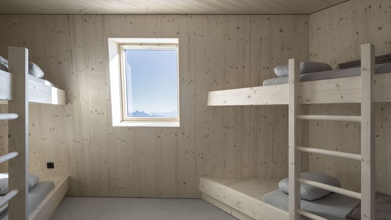 Wie das restliche Interieur sind auch die Gästezimmer mit unbehandeltem Fichtenholz vertäfelt und möbliert. Der Blick durch die Fenster lässt die Berglandschaft wie ein Gemälde erscheinen. Fotos: Velux / Stifter + Bachmann /Oliver Jaist