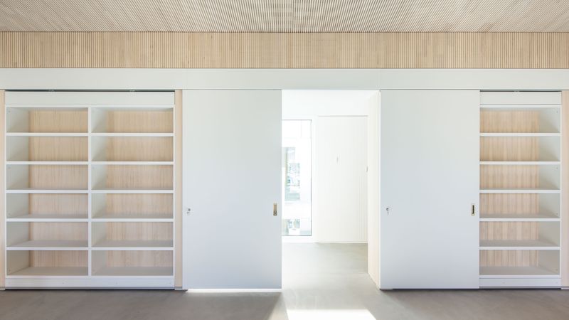 Doppelnutzen: Den tragenden Wandschotten entlang der Flure wurden büroseitig Schrankzonen vorgelagert. Mit Schiebetüren zwischen den Schränken lassen sich die Open-Space-Büros zum Flur hin schließen. Foto: Lignotrend / Foto: Olaf Herzog, Waldkirch