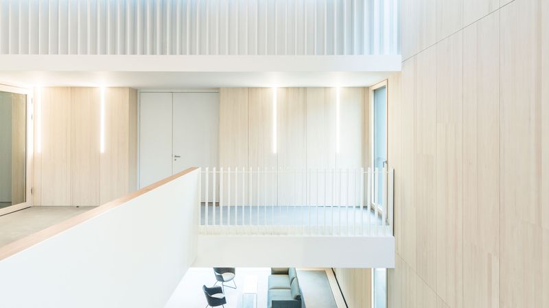 Spektakuläre Raumansichten bietet das Treppenhaus über drei Geschosse hinweg. Die Innenräume sind mit hellen, eleganten Echtholzoberflächen an Wänden und Decken ausstattet, die auch visuell für angenehme Ruhe sorgen. Foto: Lignotrend / Foto: Olaf Herzog, Waldkirch