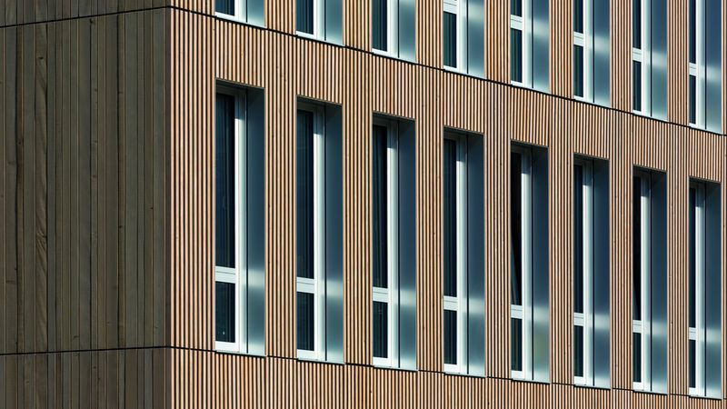 Das neue Schulgebäude von außen mit Weißtannen-Fassade und Fensterlaibungen aus eloxiertem silbernem Aluminiumblech. Foto: Erne AG Holzbau | Raumwerk & Spreen Architekten Arbeitsgemeinschaft | Thomas Koculak