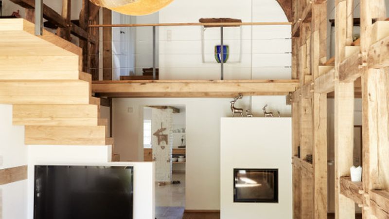Einige Räume sind nicht durch Wände voneinander getrennt. So entsteht offener, heller Wohnraum mit vielen Holzbalken. Foto: KfW-Bildarchiv / Claus Morgenstern