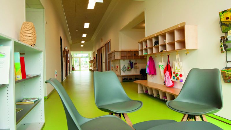 Auch in Nebenbereichen wie Fluren, Ankleidungs- und Kocharealen ist das Gestaltungskonzept von hellen Räumen mit Rot- und Grünakzenten deutlich erkennbar. Foto: Swiss Krono Tex GmbH & Co. KG / Foto: tm studios