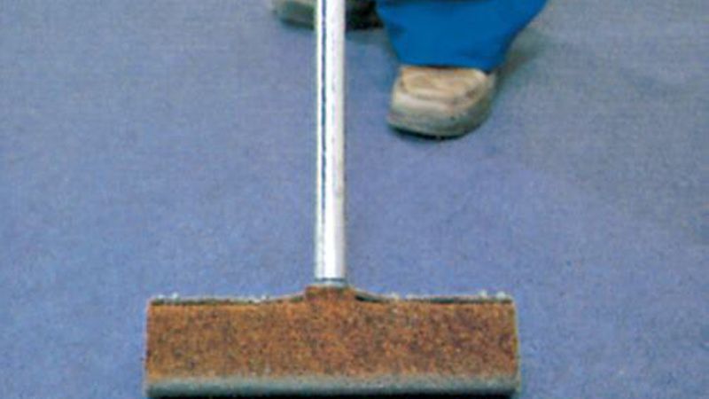 Wichtig ist, dass der Belag sorgfältig ins Kleberbett gedrückt wird. Das erfolgt mit einem Anreibeisen (mit Nadelvlies überzogen) … (Bild: DLW Flooring)