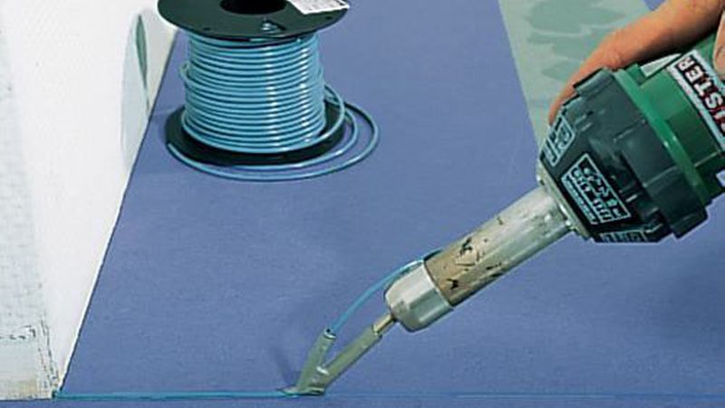 Mit einem Handschweißgerät wird eine farbliche Schweißschnur erhitzt und in die Fuge gedrückt, wo sie wieder abkühlt. (Bild: DLW Flooring)