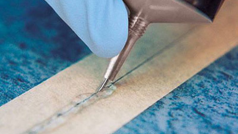 Um die bestmögliche Abdichtung zu erreichen, müssen Sie die Nadel tief in die Naht eindrücken und langsam durchfahren. Bei idealer Dosierung entsteht ein etwa 5 mm breiter Flüssigkeitsfilm auf dem Klebeband. (Bild: Werner Müller GmbH)