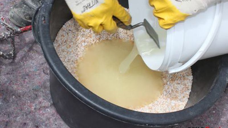 In einer großen sauberen Mörtelwanne werden Steine und Kunstharz gut durchgemischt. Dazu reicht eine Bohrmaschine mit Rührquirl. (Bild: Renofloor)