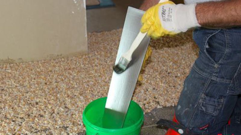 Damit der Glätter nicht am klebrigen Harz hängen bleibt, wird er regelmäßig mit einer Seifenlauge eingepinselt. (Bild: Renofloor)