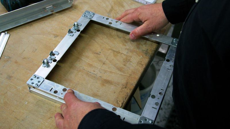 Rahmenmontage: Rahmen und Klappe sind aus Einzelteilen zusammengesetzt. Dadurch lassen sich ohne Zeitverlust auch Sonderformate fertigen, die sich nachträglich sogar ändern lassen.