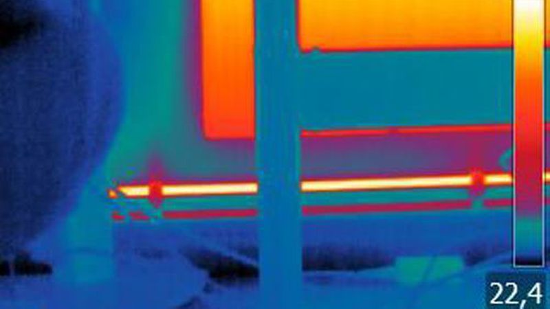 Wärmebildaufnahme im Haus: Das hier untersuchte Objekt (Heizkörper mit Leitungen) befindet sich hinter einem Tisch und einigen Kabeln. (Bild: Flir Systems)