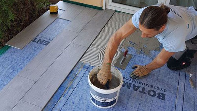 Die plankenförmigen Fliesen werden direkt auf der Verbundabdichtung verklebt. Bild: Botament