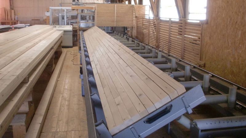 Suttner Massivholzbau fügt mit Hartholzdübeln Lamellen zu Brettstapelelementen. Dafür werden die Holzdübel in einer speziellen Dübelmaschine hydraulisch in die vorgebohrten Bohlen eingepresst.