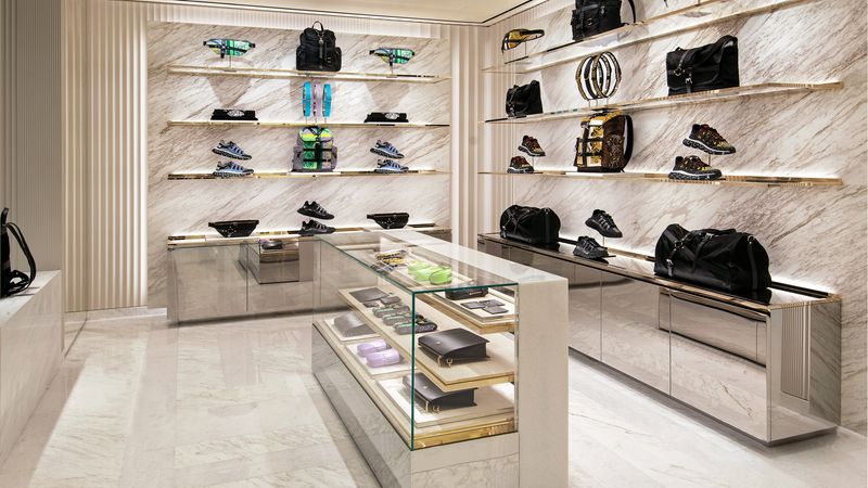 Marmor in richtungsgebundener Äderung setzt die Produkte in Szene. Die säulenartigen, kannelierten Formteile an der hinteren Wand links sind klassische Elemente des Versace-Stils.