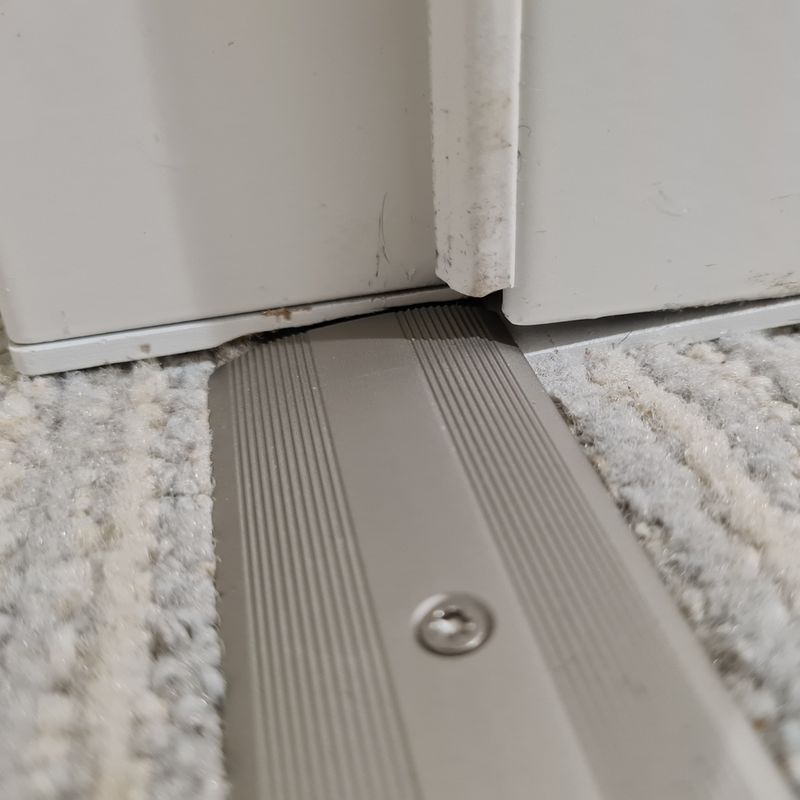 Zarge zu hoch eingebaut, mit Holzkeilen „verlängert“, nicht dauerelastisch abgedichtet und Bodenschwelle zu schmal