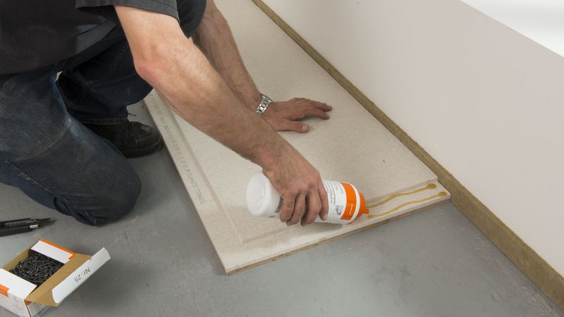 Im Falzbereich den „Fermacell Greenline“-Estrichkleber auftragen ...