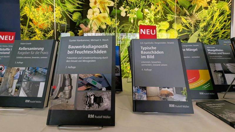 Die Fachbuchausstellung von RM Rudolf Müller Medien mit Neuauflagen der Titel „Typische Bauschäden im Bild“ und „Schadstoffe im Baubestand“.