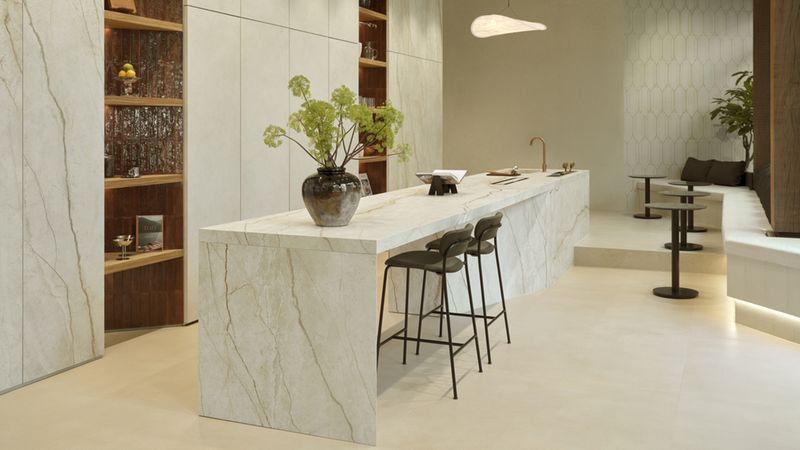 Die Küche aus mittiger Insel und Schränken mir keramischen Fronten wurde mit Materialien der Kollektion „The Top Stone Look“ in der Farbstellung  „Silver Root White“ gefertigt.