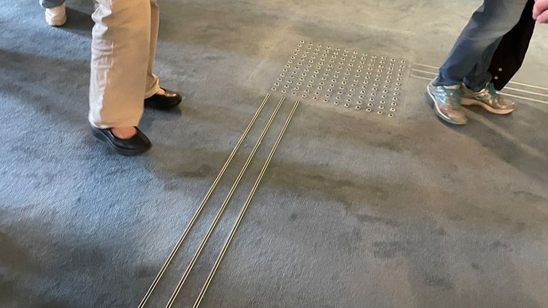 Auch im Teppich sorgen taktile Leitelemente für Orientierung. Für die Leitstreifen wurden Fugenprofile zweckentfremdet und sorgen für dauerhaften Halt, da sie direkt auf dem Estrich verankert sind.