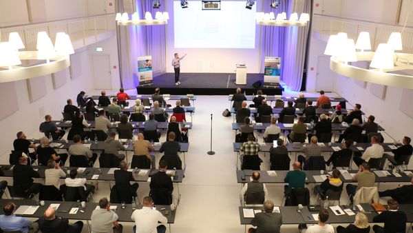 Zuhörer:innen in einem Vortragssaal.