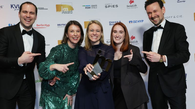 Gewinner in der Kategorie People and Culture Management posieren vor der Sponsorenwand