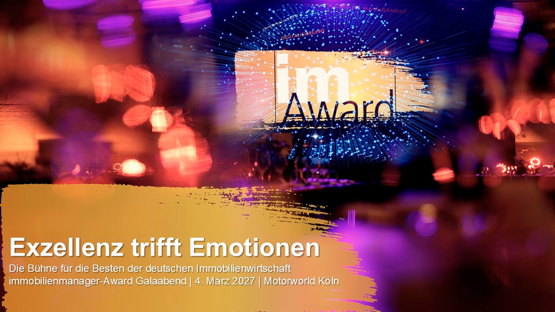 Ein atmosphärisches Foto der Bühne beim immobilienmanager-Award Galaabend in der Motorworld Köln. Das Hauptmotiv ist das leuchtende 'im Award'-Logo, das vor einem feierlich illuminierten Hintergrund mit dramatischen Lichteffekten und Bokeh-Unschärfe präsentiert wird. Im Vordergrund befindet sich eine grafische Einblendung mit dem Motto 'Exzellenz trifft Emotionen'.
